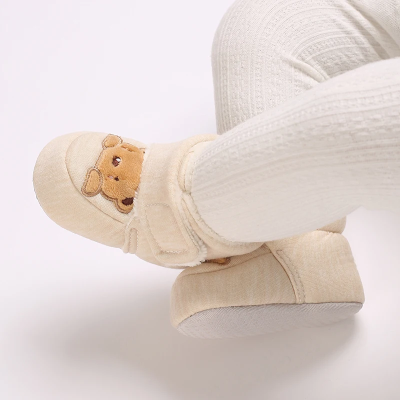 Zapatos infantiles afelpados colocados juntos sobre una superficie clara