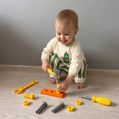 Niño jugando con herramientas de juguete y piezas de construcción